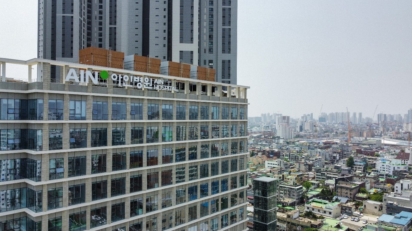The AIN Hospital building in Incheon, with the AIN sign at the top, overlooking the city