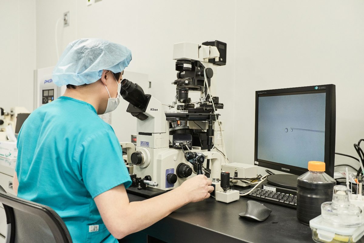 An embryologist working at a microscope in the fertility laboratory