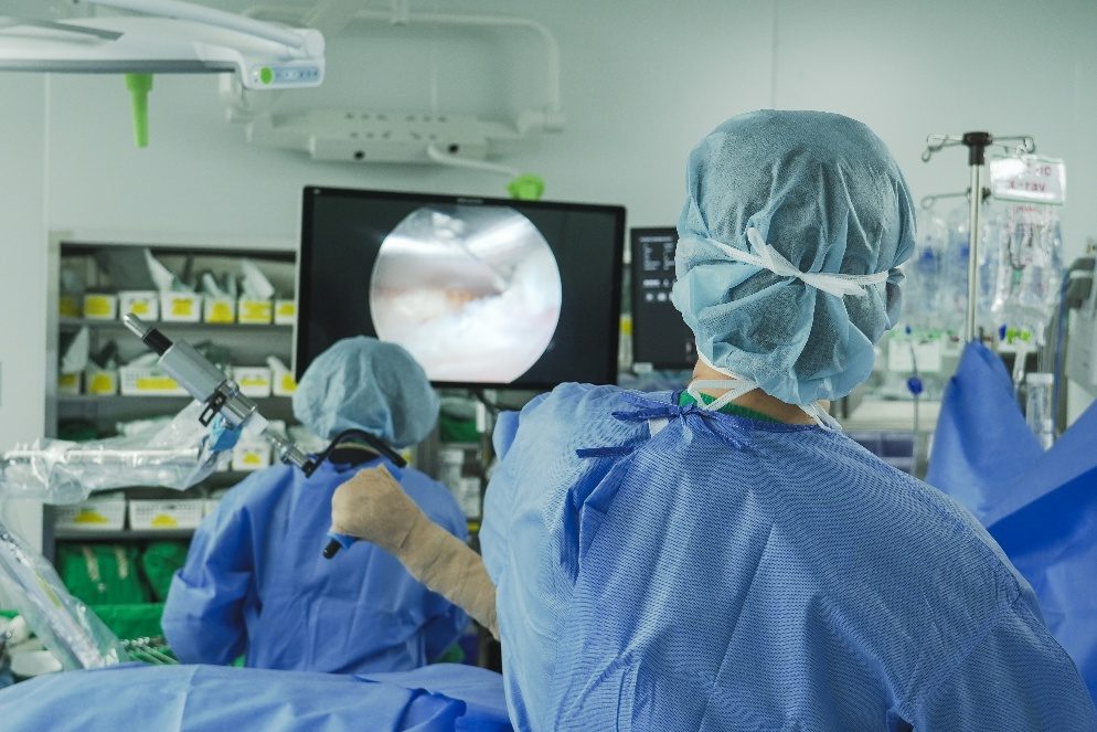 Surgeons performing spinal endoscopic surgery while watching the endoscope monitor