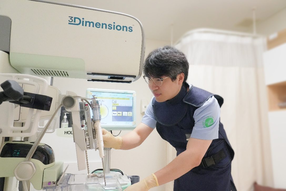 A radiologic technologist preparing a 3D mammography system